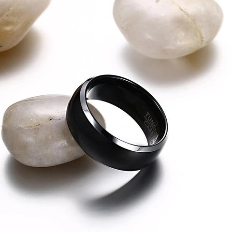 Image of Black Men's Tungsten Wedding Band with Silver Edging Leaning on White Rock | The Black Pearl