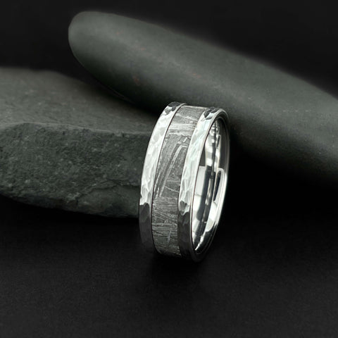 Image of Cobalt Men's Wedding Band With Meteorite Inlay and Hammer Finish Next To Black Rock | The Leo