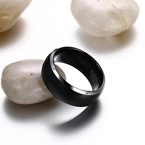 Black Men's Tungsten Wedding Band with Silver Edging Leaning on White Rock | The Black Pearl