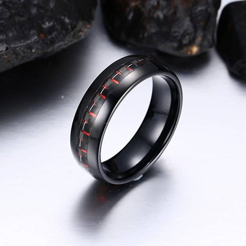Image of Black Tungsten Men's Wedding Band with Red Carbon Fiber Inlay With Rocks In Background | The Commander 