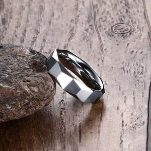 Tungsten Men's Wedding Band with Geometric Design Leaning Against Rock | The Flywheel