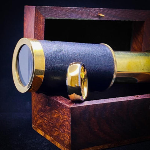 The Doubloon ring on a wood box with an antique telescope