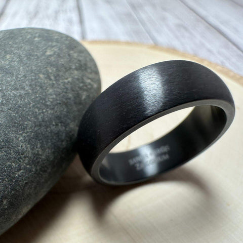 Black Zirconium Men's Wedding Band with Dome Design Against Gray Rock | The Electron